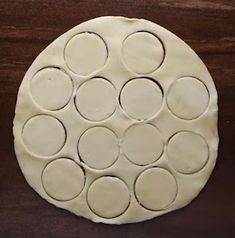 an uncooked pizza dough with circles on it