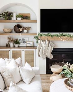 a living room filled with furniture and a flat screen tv mounted on the wall above a fireplace