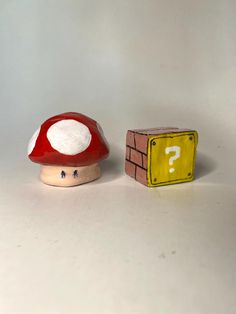 a toy mushroom sitting next to a yellow and white box with question mark on it