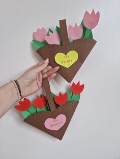 someone is holding up some flowers made out of construction paper and cardboard with the words happy valentine's day written on it