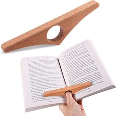 a hand holding an open book with a wooden cross on it and a knife next to it