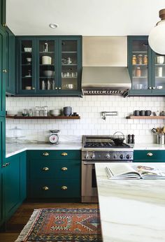 a kitchen with green cabinets and white tile backsplash, an instagram from instagram com