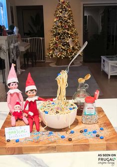 two elfs are sitting on a table eating spaghetti