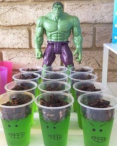 there are many plastic cups that have plants in them and a hulk figure on top