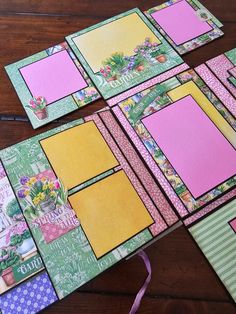 several different colored papers are laid out on a table with pink and green trimmings