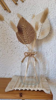 a glass vase with some dried plants in it