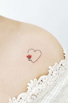 a woman with a small heart tattoo on her shoulder