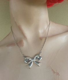 bow necklace sterling silver (925) Beautiful large piece Attached chain..please convo me to see what chain is available at purchase.. The bow is 35 mm x 27 mm (1 1/2 '' x 1 '') Her total weights is 12gms Her total length is 42 cm ( 16 1/2 '') The chain is soldered to the bow.. And yes it I can adjust ..shorter if you prefer The chain in the photo us sold..but I can make this pendant on any chain ..also looks beautiful in gold Has a matching now ring also Silver Bow Jewelry For Evening, Silver Bow Necklace For Wedding, Silver Sterling Silver Necklace With Bow, Vintage Ribbon Necklaces For Party, Formal Sterling Silver Ribbon Jewelry, Formal Sterling Silver Jewelry With Ribbon, Vintage Ribbon Necklace For Gift, Retro Silver Necklace For Evening, Silver Jewelry With Ribbon For Party