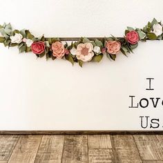 the wall is decorated with paper flowers and words that read, i love u us