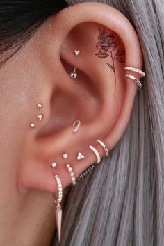 a woman wearing ear piercings with flowers and hearts on them