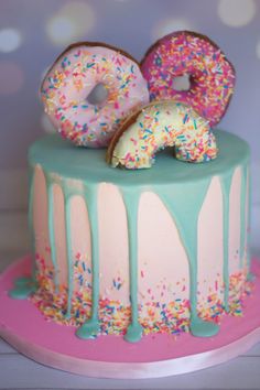 a cake with sprinkles and donuts on top