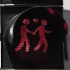 a red traffic light with an image of two people holding hands