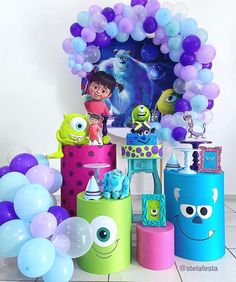 a birthday party with balloons, decorations and monsters on the table in front of it