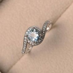 an engagement ring with a blue topazte surrounded by diamonds