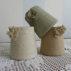 two hats sitting on top of a table next to each other, one is made out of burlap