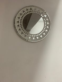 a round mirror hanging on the wall