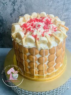 a cake with bananas and white icing sitting on top of a yellow platter