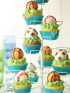 cupcakes with green frosting and sports balls on top are arranged in a tower