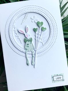 a close up of a greeting card with an animal on the front and green leaves in the back