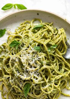 a white bowl filled with pasta and pesto sauce