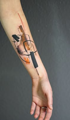 a person's arm with a tattoo on it and an orange object in the background