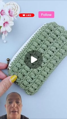 a hand holding a crocheted pouch with the video below it