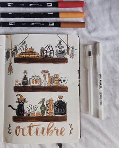 an open notebook with writing on it next to some markers and pencils in front of them