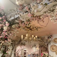 a room filled with lots of pink flowers and hanging chandelier over the top of it