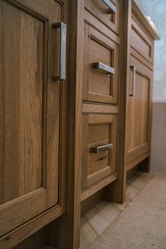 a close up of a bathroom vanity with wooden drawers and pulls on the cabinet doors