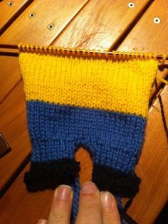 a hand is holding up a knitted item