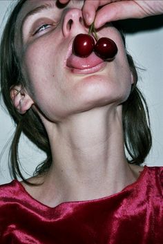 a woman with two cherries on her nose