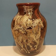 a brown vase with two horses on it