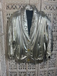 This stylish ladies' vintage casino jacket adds a touch of class to any outfit. It's made from a shiny light gold fabric and features 3 intricately detailed gold buttons. The perfect way to add some dazzle dazzle for a night out or special occasions. Size L/XL Gold Long Sleeve Outerwear With Button Closure, Gold Winter Blazer With Buttons, Gold Blazer With Buttons For Winter, Gold Party Blazer With Gold Buttons, Gold Blazer With Gold Buttons For Spring, Glamorous Metallic Formal Outerwear, Gold Blazer With Button Closure For Fall, Gold Winter Outerwear With Buttons, Gold Buttoned Outerwear For Winter