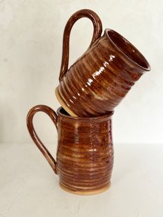 two brown mugs stacked on top of each other