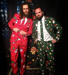 two men dressed in christmas pajamas posing for a photo with one man wearing a beard