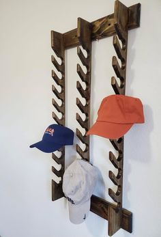 three hats are hanging on the wall with a hat rack attached to it's side