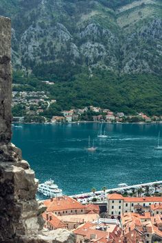 an aerial view of some boats in the water and buildings near by with mountains in the background