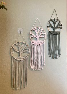 three metal wall hangings with trees on them