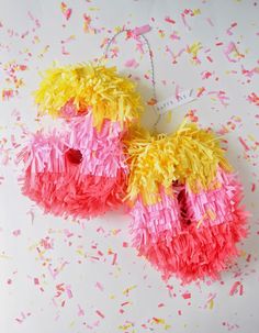 two pink and yellow pinatas with sprinkles on them