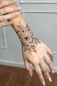 a woman's hand with flowers tattooed on it