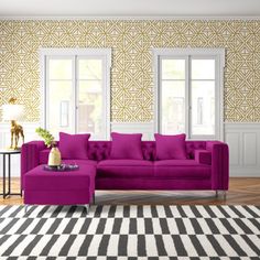 a living room with a purple couch and ottoman