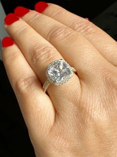 a woman's hand with a ring on it and a diamond in the middle