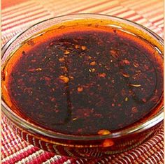 a glass bowl filled with sauce sitting on top of a table