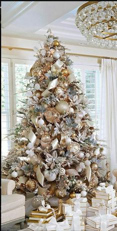 a decorated christmas tree with gold and silver ornaments in a white living room filled with presents