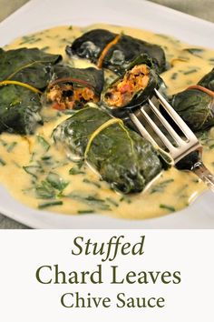 stuffed chard leaves with chive sauce on a white plate and a fork in it