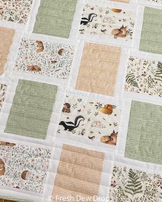 a quilted table topper with animals and leaves on the edges, sitting on a wooden surface