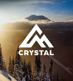 the logo for crystal is shown on top of a snowy mountain with pine trees in the foreground