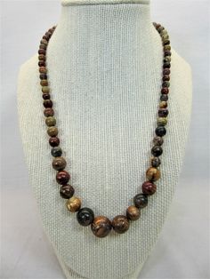 Polished natural stone beads with beautiful earth tone colors. All shades of browns, rusts, greens and more. Graduating bead size from small about 5mm to larger about 15mm at the middle. Lobster clasp. The necklace measures 19'' with a 2 1/2' extender chain.  Please check the pics carefully as they are part of the description. All of my items are vintage and I try to mention any flaws I find.  I leave the cleaning and polishing to the buyer as some prefer the pieces in their found condition. If Brown Polished Bead Round Necklaces, Brown Polished Beads Round Necklace, Brown Necklaces With Polished Beads, Brown Polished Beads Necklace, Brown Gemstone Beads Round Necklaces, Brown Round Bead Necklaces For Jewelry Making, Brown Necklace With Polished Round Beads, Brown Single Strand Necklace With Round Beads, Earthy Brown Beads For Jewelry Making