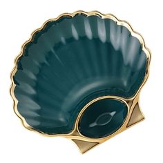 a green shell shaped dish with gold trim