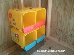 three plastic storage containers stacked on top of each other in a room with wood walls